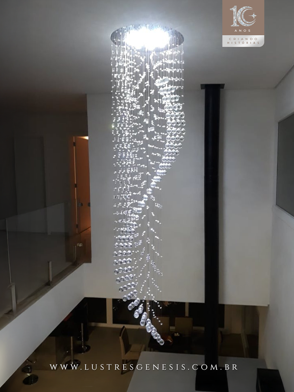 Lustre de cristal design S Rico instalado em sala com pé direito duplo, destacando cristais K9 legítimos da Linha Kria, ideal para ambientes sofisticados.